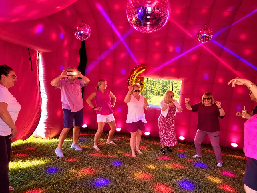 Guests dancing inside PopHaus under pink lighting and disco balls