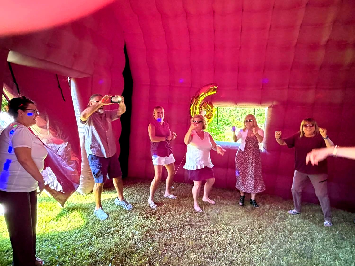 Guests dancing inside the inflatable nightclub lit pink
